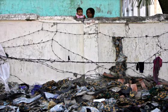 Residents watch the ambandoned uniforms of the rebel Bangladesh Rifles members inside the BDR headquarters in Dhaka.