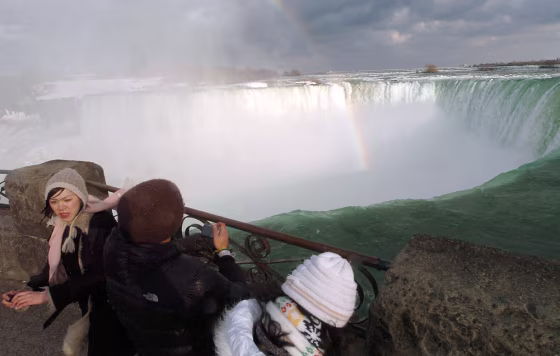 Image: Tourists look over the brink of the Horseshoe Falls at Niagara Falls, Ontario