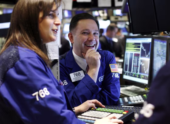 Image: A trader smiles on the floor of the New York Stock Exchange