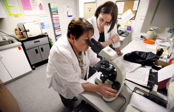 Nurse practitioner Sharon Spiller, left, and physicians assistant Tiernie Garbers, right, work in a lab at the Planned Parenthood of East Central Iowa on Tuesday in Cedar Rapids, Iowa. Jenifer Vick, a spokeswoman for the clinic, says there's been a sharp rise in the number of women who need help paying for birth control.