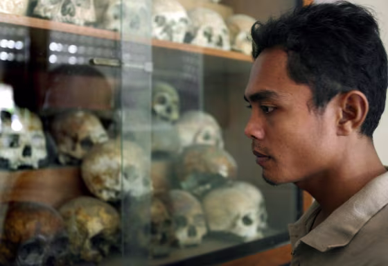 Image: A Cambodian man looks at skulls of the Khmer Rouge victims at Tuol Sleng Genocide museum
