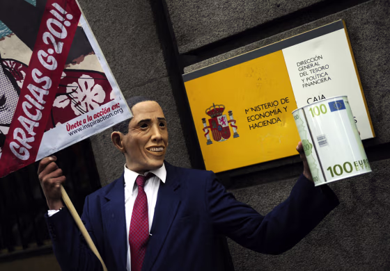 A man wearing a mask resembling President Barack Obama holds a placard reading "Crisis? Calm down, there is nothing wrong," in front of the Finance Ministry in Madrid on March 28, as part of a&nbsp;demonstration ahead&nbsp;of the G-20 summit.