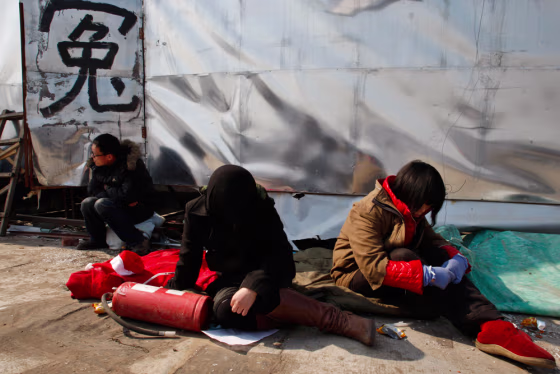 Workers of a destroyed business sit in protest next to the Chinese character for "Injustice" in February&nbsp;as they petition for help ahead of the annual meeting of the Chinese legislature&nbsp;in Beijing.