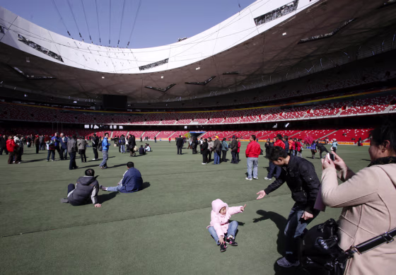 Image: Tourists walk and take photographs on the infield of the National Stadium