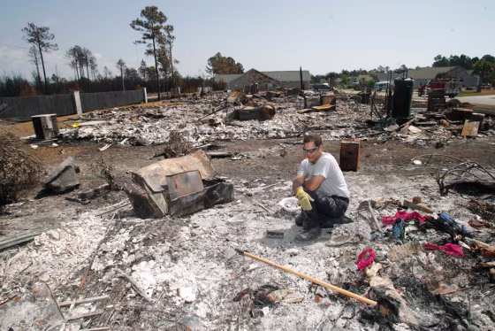 Adam Cumbo sifts through the rubble in search for his mother-in-law's class ring in what used to be his in-laws house on Saturday in North Myrtle Beach, S.C. 
