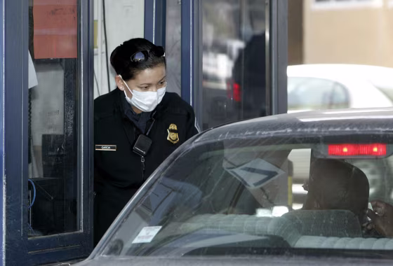 Image: Customs and Border Protection agent wears a protective mask