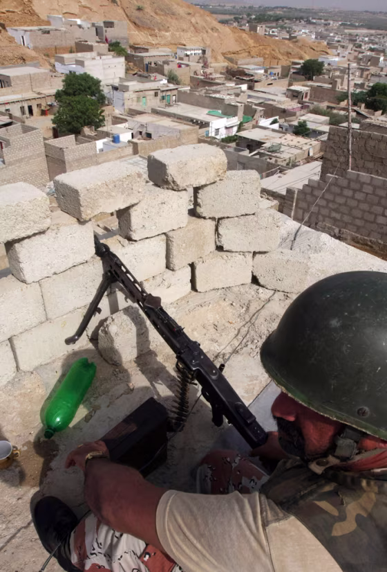 A soldier of Pakistani paramilitary force sits in a bunker in a troubled area of Karachi in Pakistan on Thursday. A slew of gun attacks in the Pakistan's biggest city killed at least 26 people Thursday,&nbsp;rattling a country already tense over a military offensive against the Taliban.