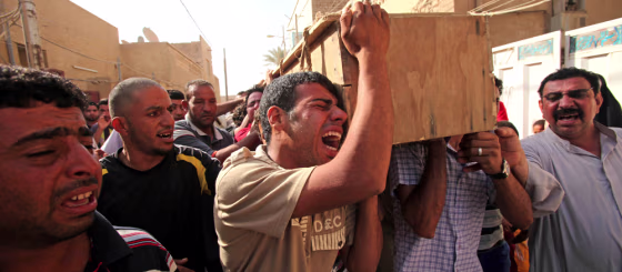 Image: Men carry the coffin of a relative killed in a bombing in the main Shiite district in Baghdad.