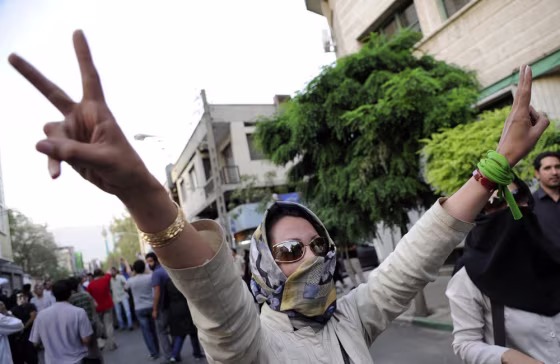 Image: A supporter of pro-reform leader Mir Hossein Mousavi, flashes victory signs during a gathering near Ghoba Mosque in Tehran, Iran