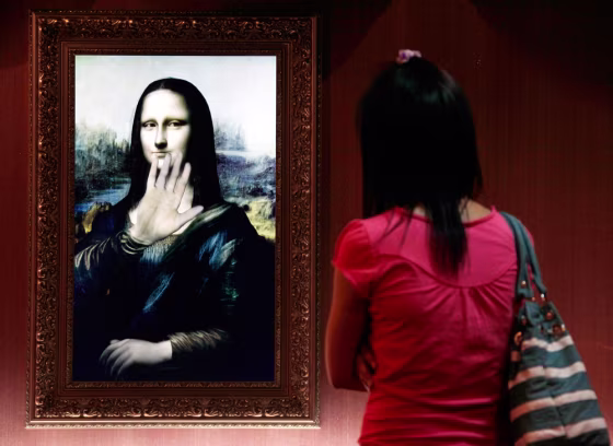 Image: A visitor looks at a three-dimensional, holographic version of the Mona Lisa portrait in Beijing