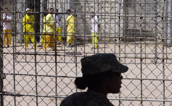 Image: A U.S. soldier keeps watch as detainees spend time at Camp Bucca in southern Iraq