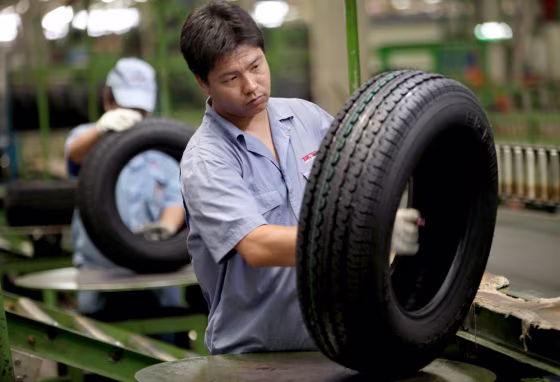 Image: Workers of the Beijing Capital Tire factory check tires as part of quality control procedure