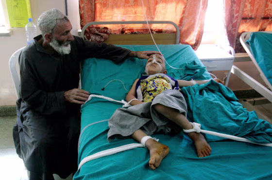 Image: An Afghan boy is comforted aftering being injured in an explosion