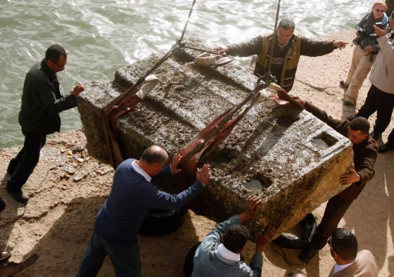 Image: Workers handle an ancient Egyptian granite tower that was retrieved from the Mediterranean Sea, at Alexandria's eastern harbour