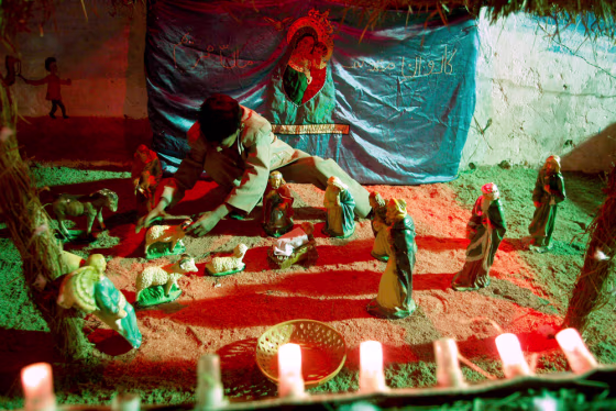 Image: A child arranges statues to celebarte Christmas