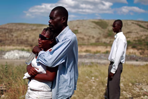 Image: People react during a memorial service in Haiti