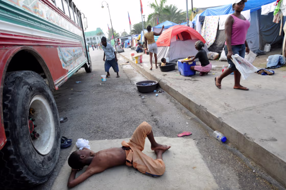 Image: A Haitian boy rests next to a camp set up in front of the Presidential Palace in downtown Port-au-Prince