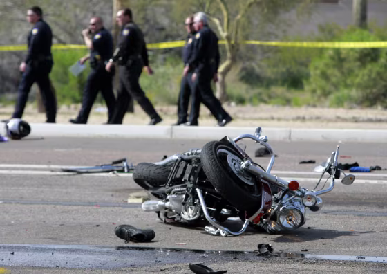 Phoenix police detectives look over the scene of a accident involving multiple motorcycles and a trash truck on the Carefree Highway in Phoenix.