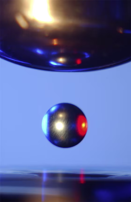 Inside a NASA Electrostatic Levitator, a ball of metal is suspended in mid-air by static electricity.