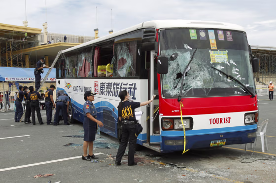 Image: Philippine National Police inspects the damage to a tourist bus during forensic examinations in Manila