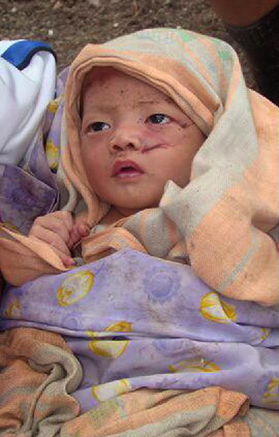 Image: Villager holds a baby survivor, orphaned by the tsunami which hit Muntei Baru Baru village, in the Cikakap subdistrict of Indonesia's Mentawai islands
