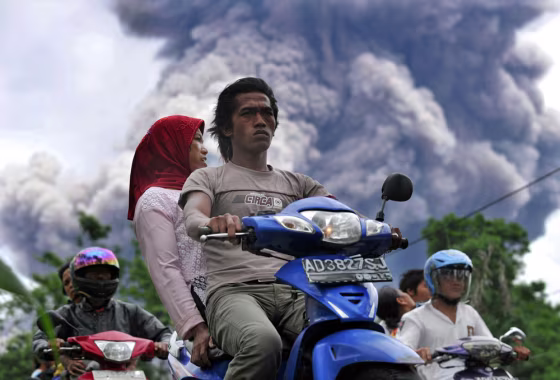 Image: Local residents leave a danger zone as MMerapi volcano releases ash clouds in Balerante village, Klaten