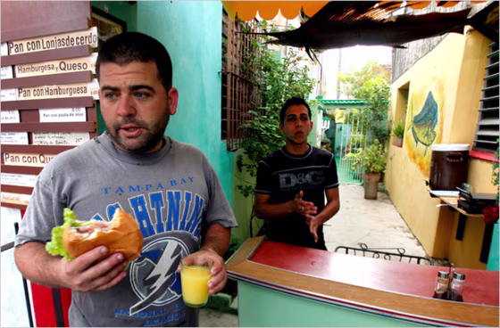 A customer takes a sandwich away from the El Dorado cafeteria in Bauta, near Havana, on Jan. 26. Cubans are taking up the government’s offer to work for themselves, selling coffee in their front yards, renting out houses, making rattan furniture and hawking everything from bootleg DVDs to Silly Bandz and homemade wine. 