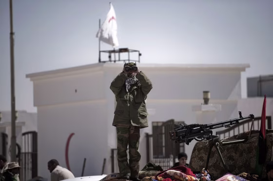 Image: A Libyan rebel fighter stands ontop of a