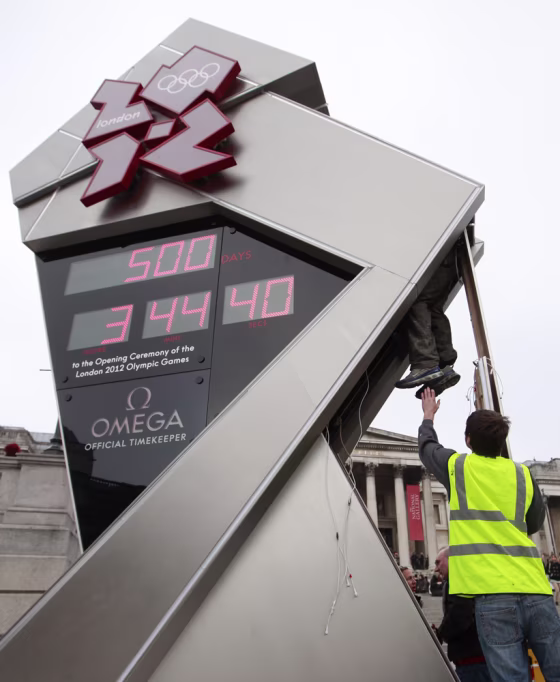 Image: A technician climbs into the Olympic countdown clock in Trafalgar Square in central London