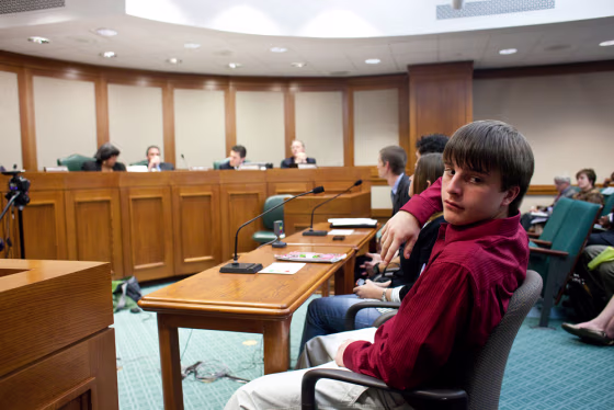 Image: Tyler Anastopoulos testifies during a state House committee meeting on abolishing corporal punishment at the State Capitol in Austin.