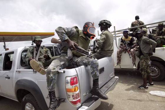 Image: Soldiers loyal to Alassane Ouattara return from fighting, at a checkpoint serving as an operating base,