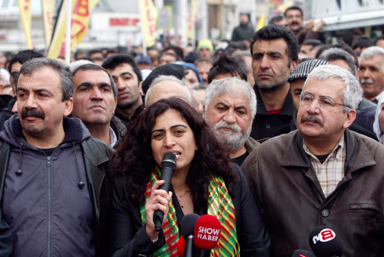 Image: BDP Parliamentarians Sebahat Tuncel (C) and Ufuk Uras (R) attend a protest against a High Election Board decision in central Istanbul on April 19