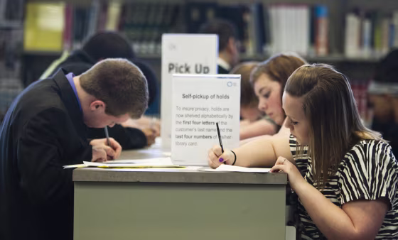 Image: job seekers fill out job applications at a teen job fair held at the Swanson Public Library in Omaha, Neb.