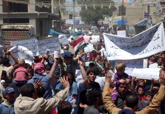 Image: Syrian anti-government protesters hold banners calling for an end to a military siege in Nawa near the southern town of Daraa on April 28.