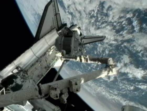 The Alpha Magnetic Spectrometer is transferred out of the space shuttle Endeavour's cargo bay by the shuttle's robotic arm on Thursday.