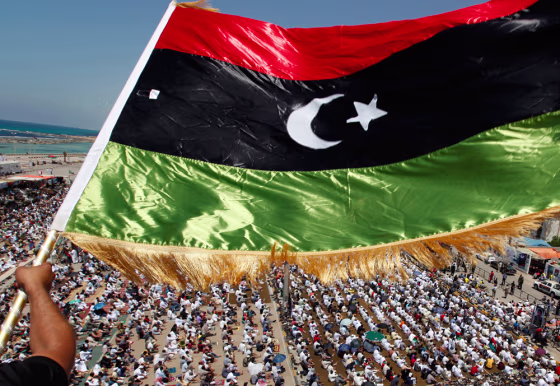 Image: A Libyan waves a Kingdom of Libya flag during Friday prayers near the courthouse in Benghazi