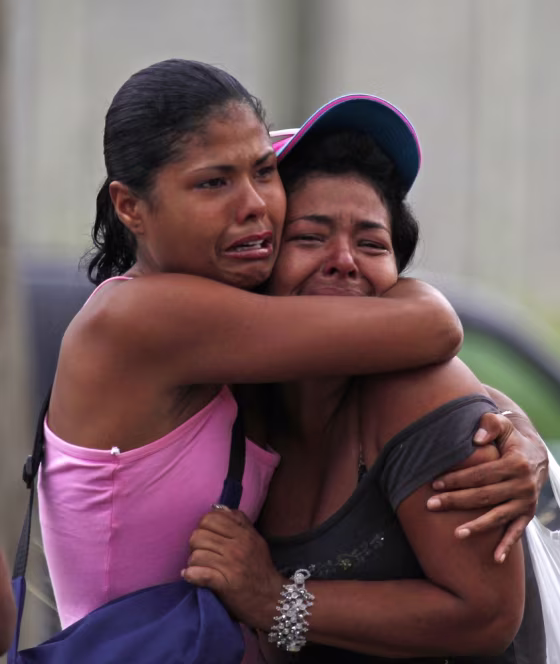 Image: Inmates' relatives embrace as they cry outside of El Rodeo I prison