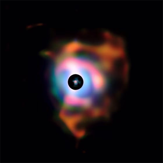 This picture of the dramatic nebula around the bright red supergiant star Betelgeuse was created from images taken with the VISIR infrared camera on ESO’s Very Large Telescope. The structure, resembling flames emanating from the star, forms because the behemoth is shedding its material into space.