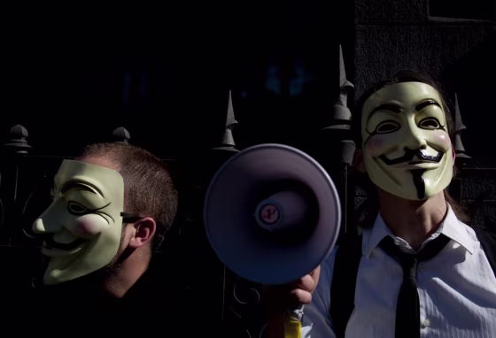 Image: People wearing masks often used by a group that calls itself \"Anonymous\"  take part in a rally in Madrid