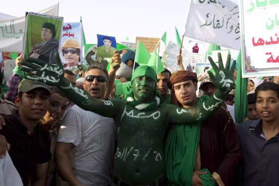 Image: Libyan men take part in a pro-government rally in Gadhafi's hometown of Sirte