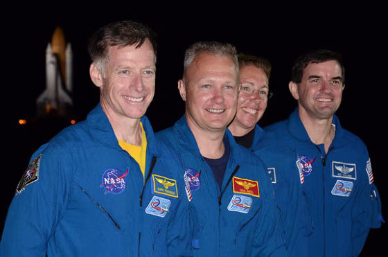 Shuttle Atlantis' final crew, commander Chris Ferguson, pilot Doug Hurley and mission specialists Sandy Magnus and Rex Walheim, stand in front of the orbiter as it rolls out to the launch pad one last time.
