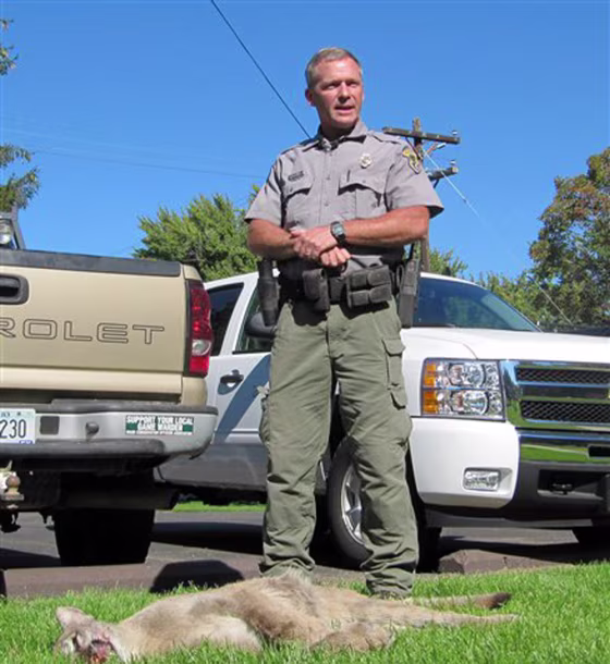 Idaho Department of Fish and Game conservation officer Matt O’Connell stands next to a mountain lion that was tracked down and killed after chasing a 10-year-old boy in southwestern Idaho.