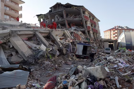 Image: Rescue workers work to save people trapped under debris after an earthquake in Ercis