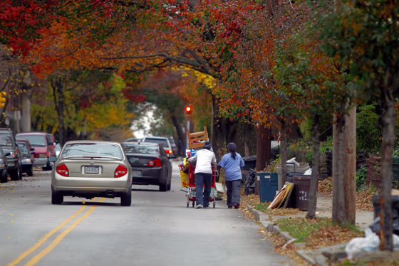 Image: People push a shopping cart loaded with items collected from the streets in the once middle-class Germantown neighborhood of Philadelphia.