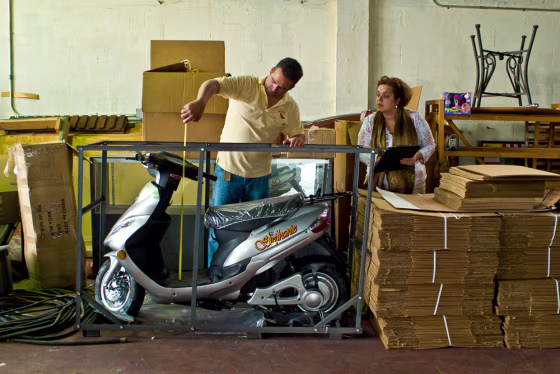 Image: Alain Tristan and his sister Marlen measure a scooter before shipping it to Cuba.