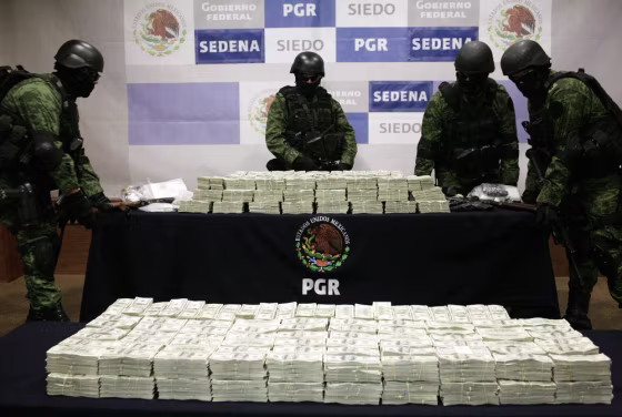 Image: Mexican soldiers arrange two tables with stacks of U.S. hundred dollar bills during a presentation to the media in Mexico City