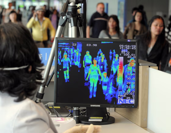 Image: A South Korean quarantine officer monitors a thermal scanner as passengers from an international flight arrive at Incheon airport.