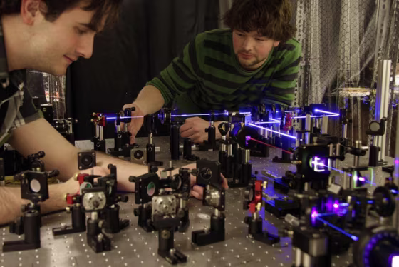 Univ. of Toronto's Dylan Mahler (l) and Lee Rozema (r) prepare pairs of entangled photons to study the disturbance caused by measuring them. Their work suggests some measurements don't wreak so much havoc on a quantum system. 