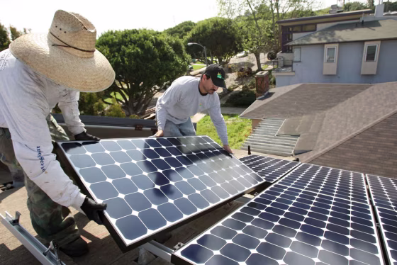Image: Employees of Solar Forward install solar electric panels