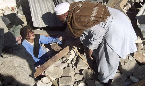 Image: A resident attempts to rescue female students from the rubble of a bombed school